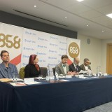 Five people sitting on a panel in front of banners for the organisers of the event - 858, the Sortition Foundation and Bright Blue